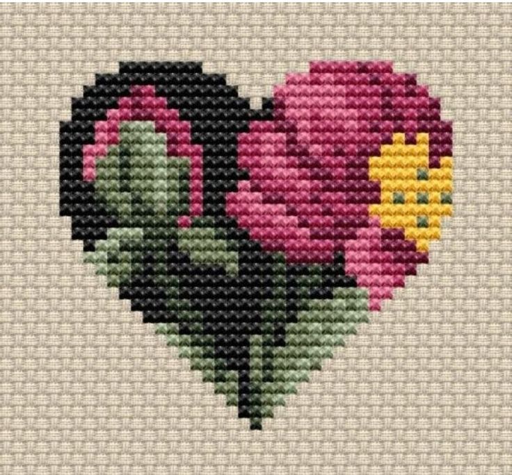 a cross stitch heart with flowers in the shape of a flower on it's side