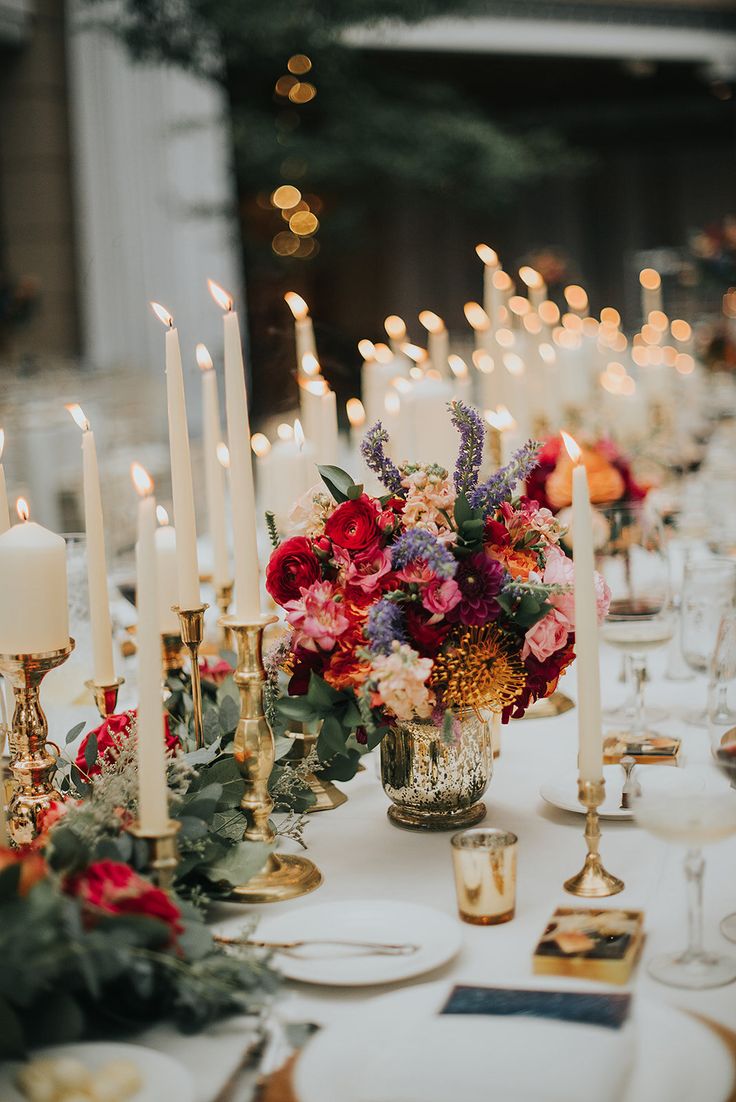 a table topped with lots of candles and flowers