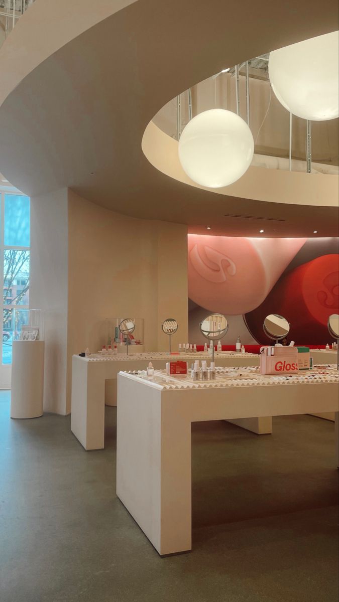 the interior of a jewelry store with white counter tops and round lights hanging from the ceiling