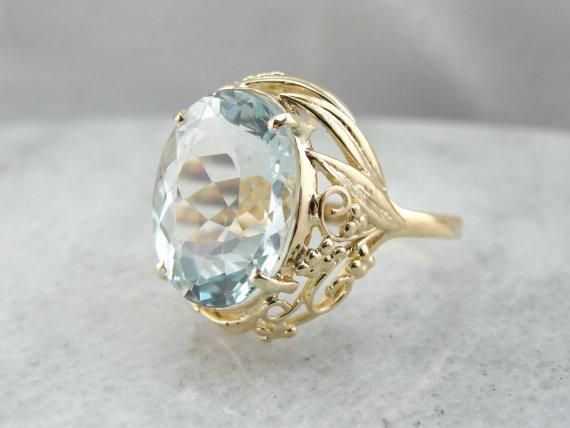 This ring is truly gorgeous! A large and beautiful Natural Blue Topaz sits in the center, with an amazing cut and vibrant, icy color! The stone is expertly cut to display the stone s color and sparkle! The simple mounting, with it's wire work embellishments, are all this stone needs to frame it to perfection! Material: 18 Karat Yellow Gold Gem: Natural Blue Topaz 13.25 Carats Gem Measurements: 12 x 16 mm, Oval Size of Ring: 9.50 Marks: "K18" stamped on the inside band Black Hills Gold Rings, Tanzanite Jewelry, Black Hills Gold, Gold Band Ring, Shiny Things, Gorgeous Jewelry, Wire Work, Topaz Ring, Perfect Ring