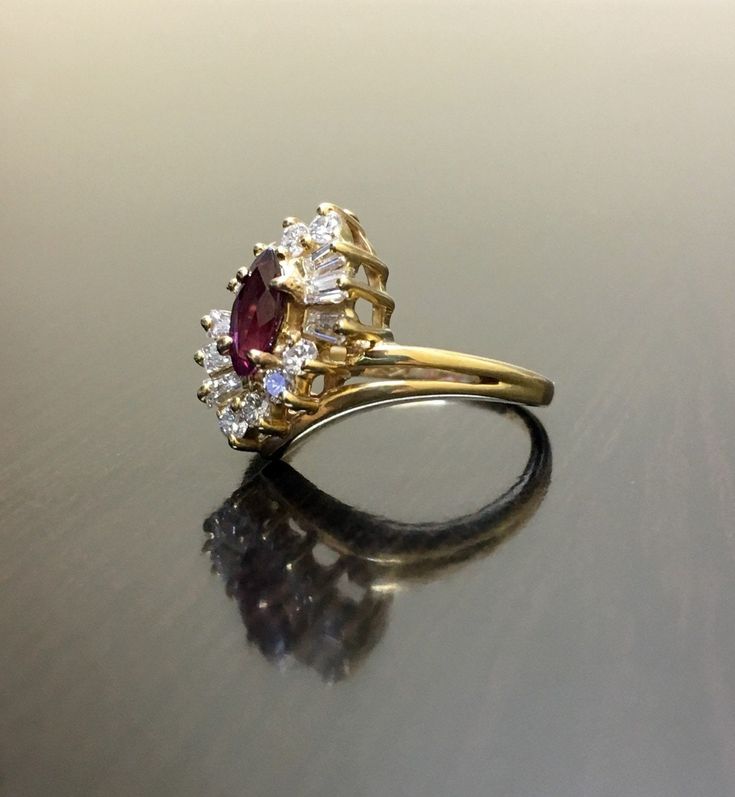 a close up of a gold ring with a red and white stone on the side