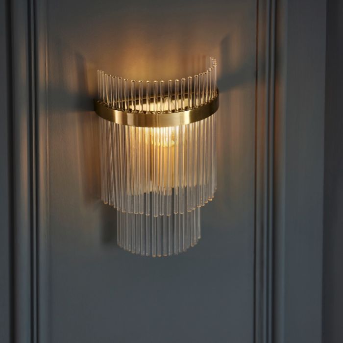 a wall light that is on the side of a door with glass rods hanging from it