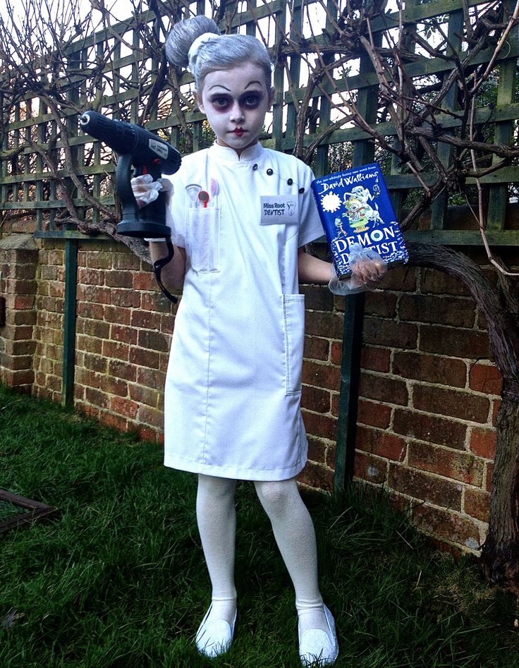 a woman dressed as a nurse holding a hairdryer