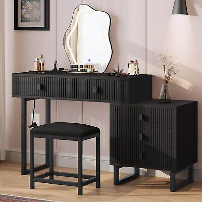 a black vanity with mirror and stool in front of it