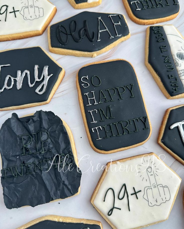 decorated cookies with black icing and writing on them