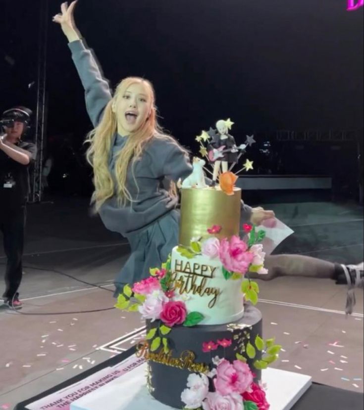 a woman standing on top of a table with a cake in front of her and the words happy birthday written on it