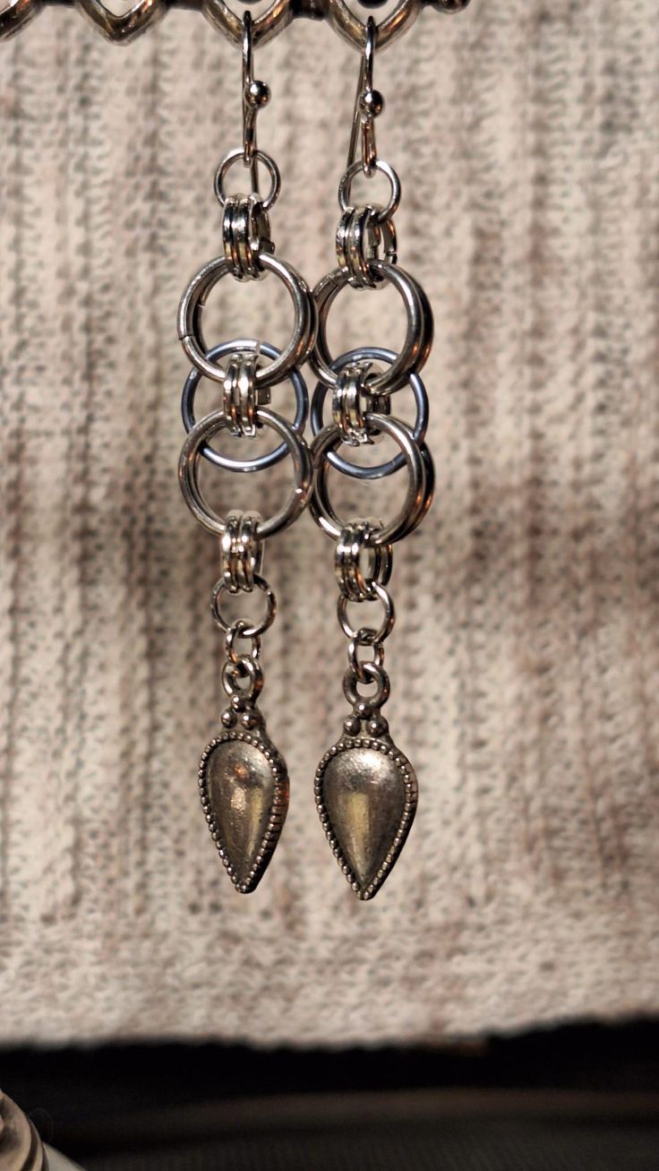 These lightweight and stylish chainmail earrings feature a sleek and simple design, perfect for daily wear. Handcrafted, each earring showcases a delicate chainmail pattern, enhanced by a charming accent at the end adding a touch of personality and flair. Despite their intricate appearance, these earrings are surprisingly light, making them comfortable to wear all day long. Whether you're dressing up for a special occasion or adding a unique touch to your everyday outfit, these handmade earrings Oddities Art, Medieval Earrings, Chain Mail Earrings, Chainmaille Jewelry Patterns, Chainmail Earrings, Chainmail Patterns, Jump Ring Jewelry, Chainmail Jewelry, Chain Maille Jewelry