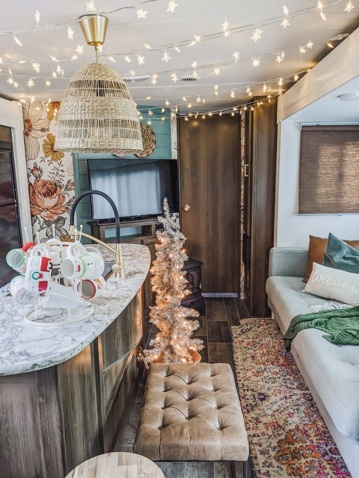 a living room filled with furniture next to a kitchen and dining area covered in christmas lights