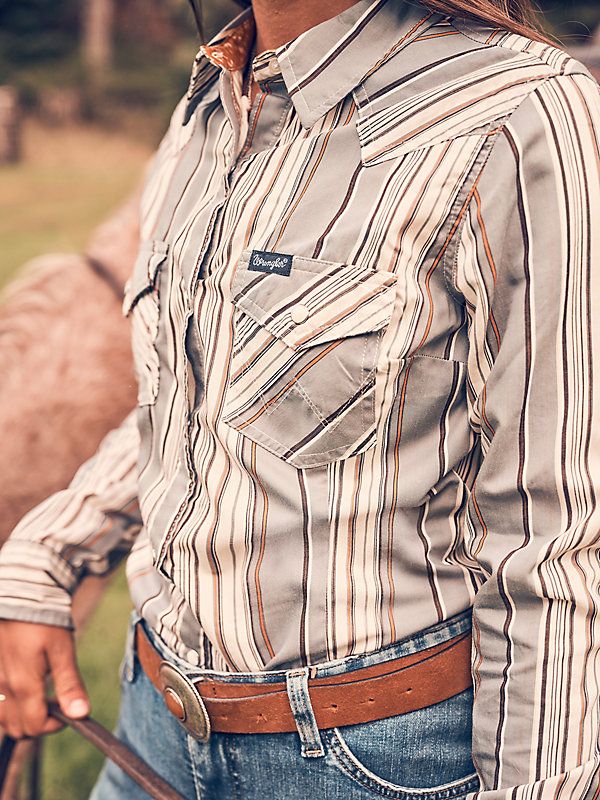 MADE TO WEAR EVERYWHERE A cowgirl can never have too many collared shirts for competition and daily life. Our Women's Wrangler Retro® All-Occasion Western Snap Dress Shirt is crafted a lightweight cotton and recycled materials blend that will keep you comfortable in everything you do. It comes with pointed yokes, pearl snaps, two chest pockets with the signature "W" stitching, and a contrast print at the cuffs. Western Button-up Tops For Rodeo, Country Style Cotton Shirt For Rodeo, Western Cotton Shirt For Country Events, Western Style Button-up Ranch Shirt, Western Style Button-up Shirt For Ranch, Western Collared Tops For Ranch, Western Style Collared Tops For Ranch, Country Style Long Sleeve Shirt For Ranch, Collared Shirts