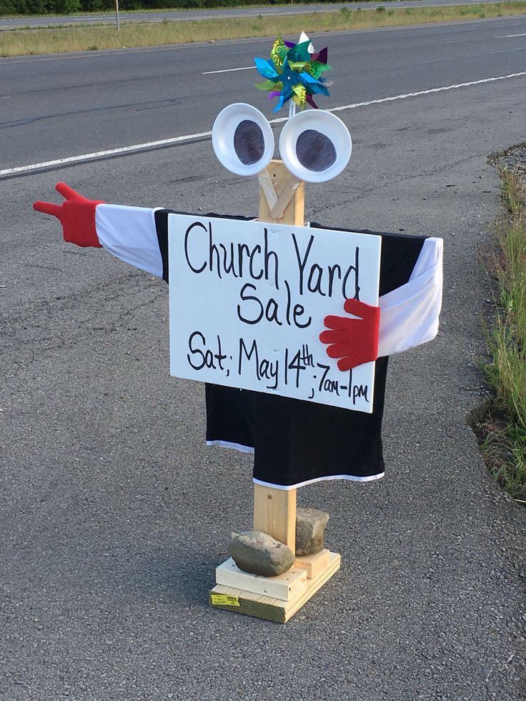 a yard sale sign on the side of the road with fake eyeballs in it