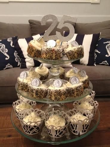 a three tiered cake stand with cupcakes on it in front of a couch