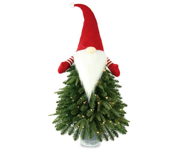 a christmas tree with a santa claus hat on it's head is in a vase