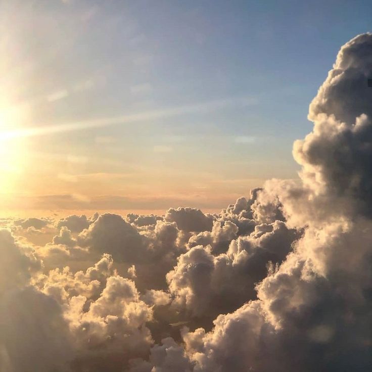 the sun shines brightly through clouds in this view from an airplane's window