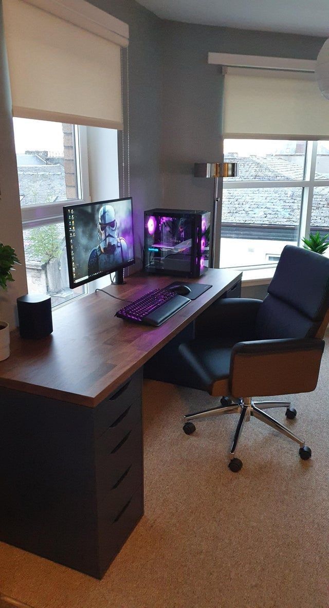 a desk with two computer monitors and a chair in front of the monitor is shown