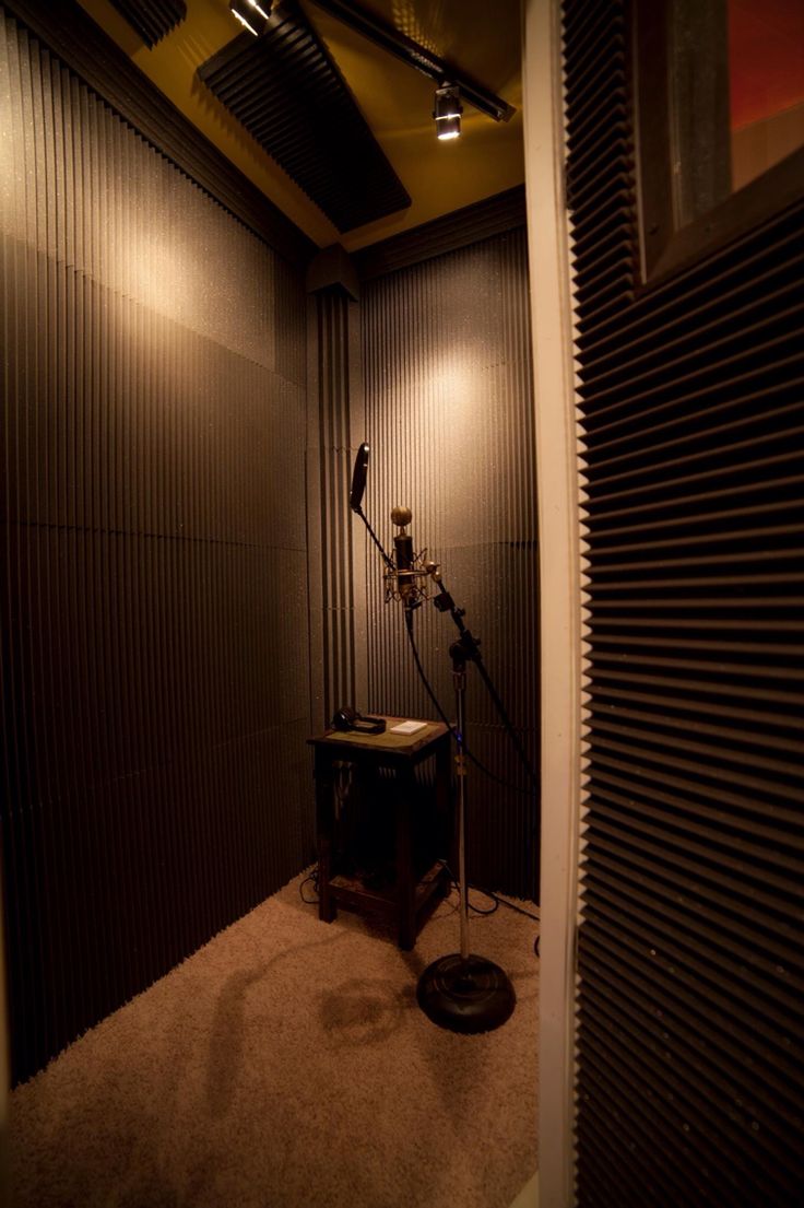 an empty room with a microphone in the corner and lights on either side of it