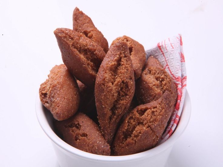 a white bowl filled with chocolate cookies on top of a table next to a red and white towel