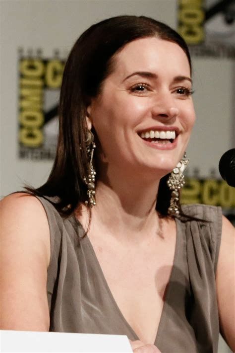 a smiling woman sitting in front of a microphone