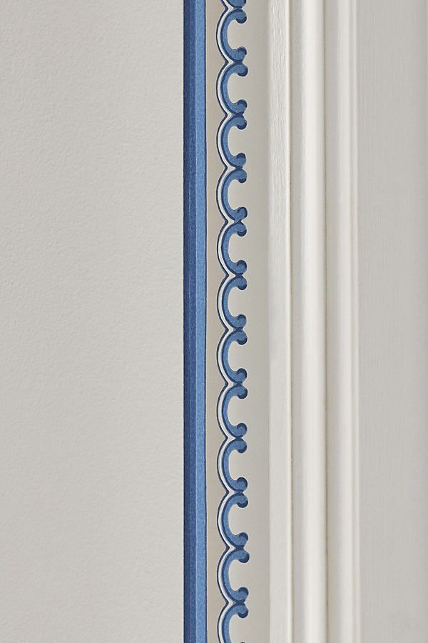 the corner of a door with blue trim on it and a white wall in the background