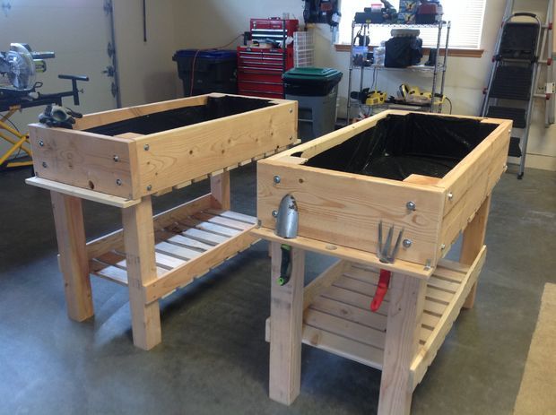 two wooden raised planters sitting on top of a floor next to each other in a garage