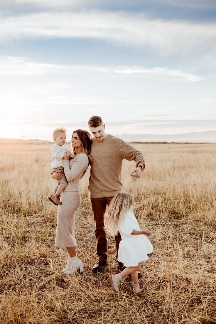 a man, woman and child are standing in the middle of a field