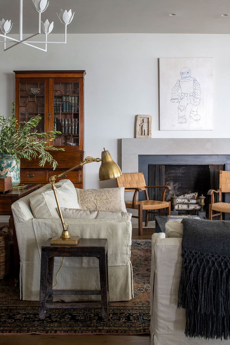 a living room filled with furniture and a fire place in front of a painting on the wall