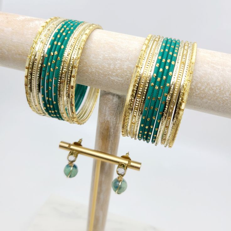 Add a touch of elegance and style to your look with our Harmony Bangle Giftset. This stunning giftset features a beautiful green bangle set and coordinating Howlite earrings. The bangle set includes a set of gorgeous green bangles with gold accents that effortlessly elevate any outfit. The intricate details of each bangle create a unique and eye-catching design that is sure to impress. The coordinating handmade earrings feature gold-plated tiny oval tops combined with raw unfinished howlite ston Green Bracelet Jewelry For Celebration, Green Bangle Cuff Bracelet For Party, Festive Green Beaded Bangle Bracelets, Adjustable Green Bracelet For Celebration, Green Adjustable Cuff Bracelet For Wedding, Adjustable Green Bracelets For Celebration, Adjustable Green Cuff Bracelet For Wedding, Festive Green Bracelets For Celebration, Green Beaded Metal Bangle Bracelets