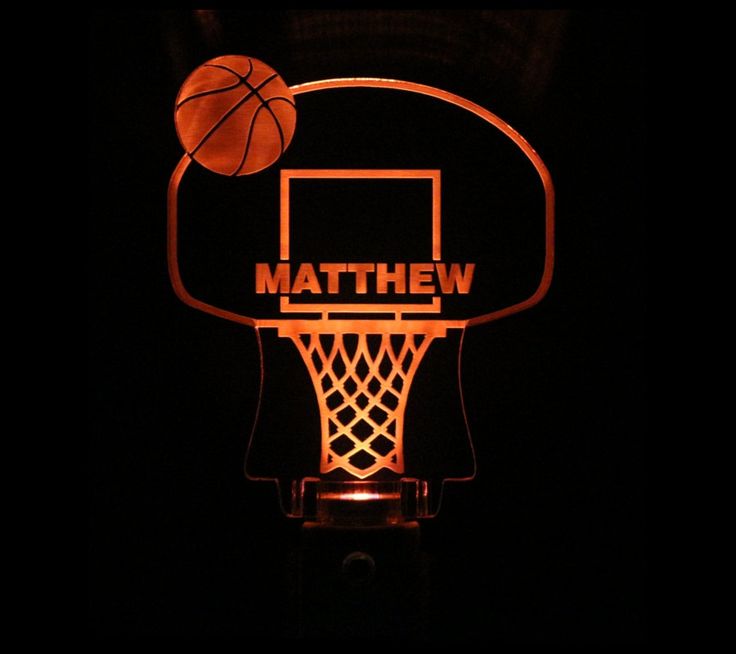 a basketball hoop with the word mathew on it is lit up in the dark