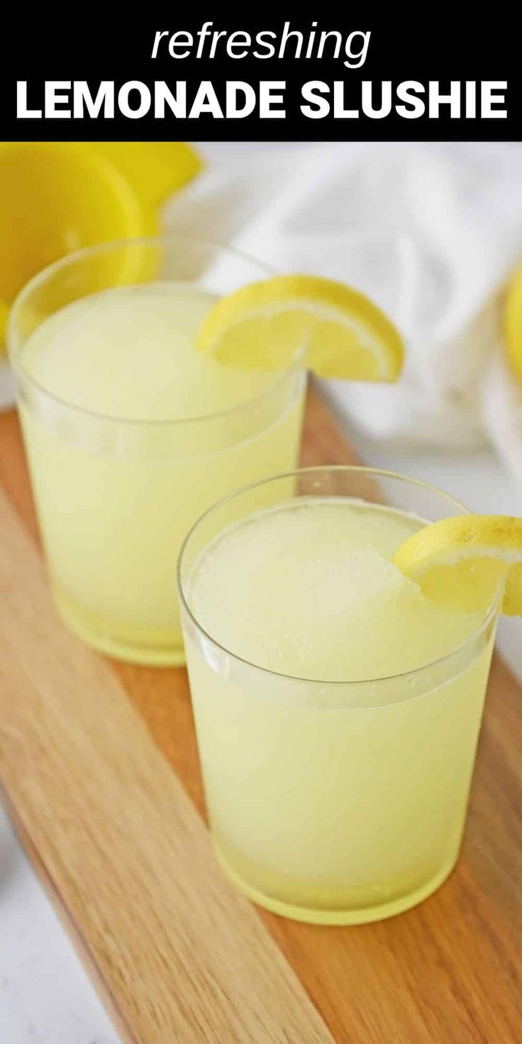 two glasses filled with lemonade slushie sitting on top of a cutting board