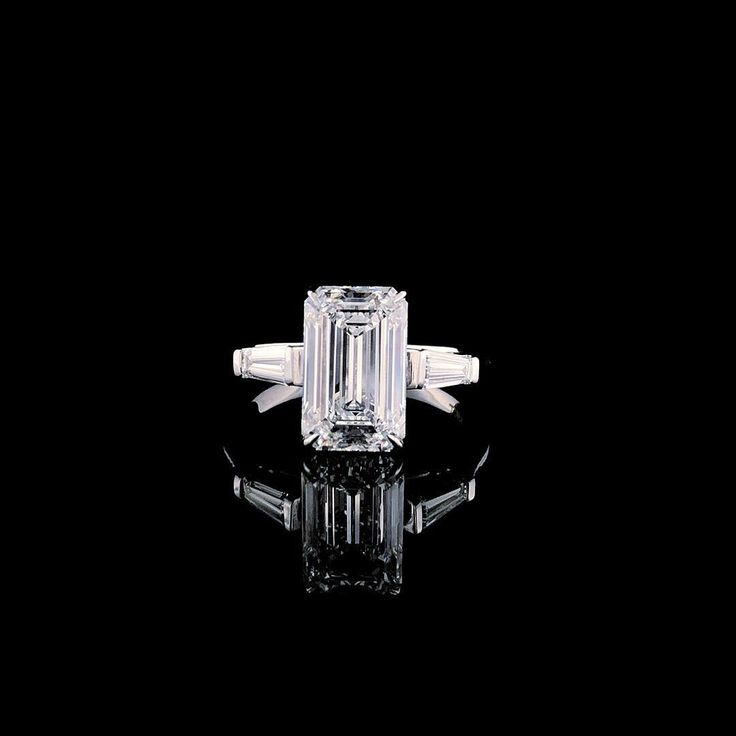 an emerald - cut diamond ring with tapered shoulders