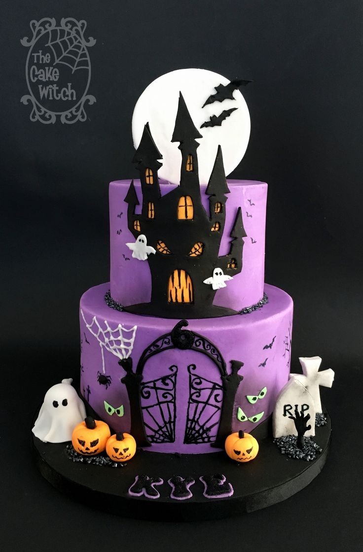 a three tiered cake decorated with purple icing and black fondant, topped with halloween decorations