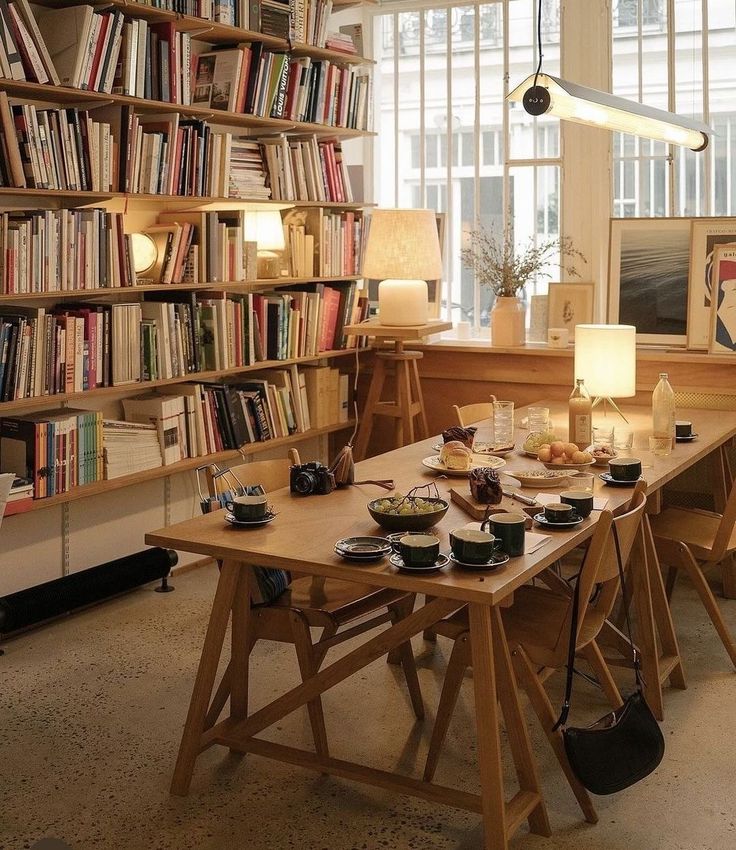 a table with food on it in front of a book shelf filled with lots of books