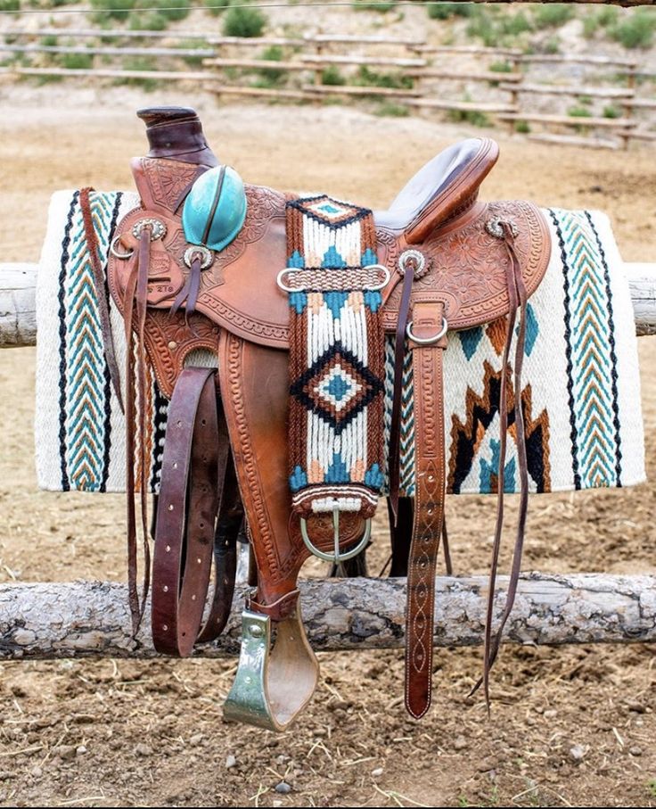 a saddled horse with turquoise and white designs on it