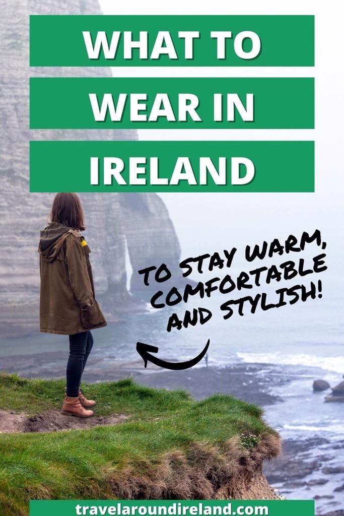 a woman standing on top of a cliff overlooking the ocean with text overlay that reads what to wear in ireland to stay warm, comfortable and stylish