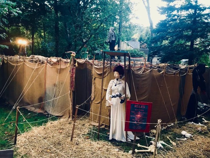 a woman standing next to a tent in the woods