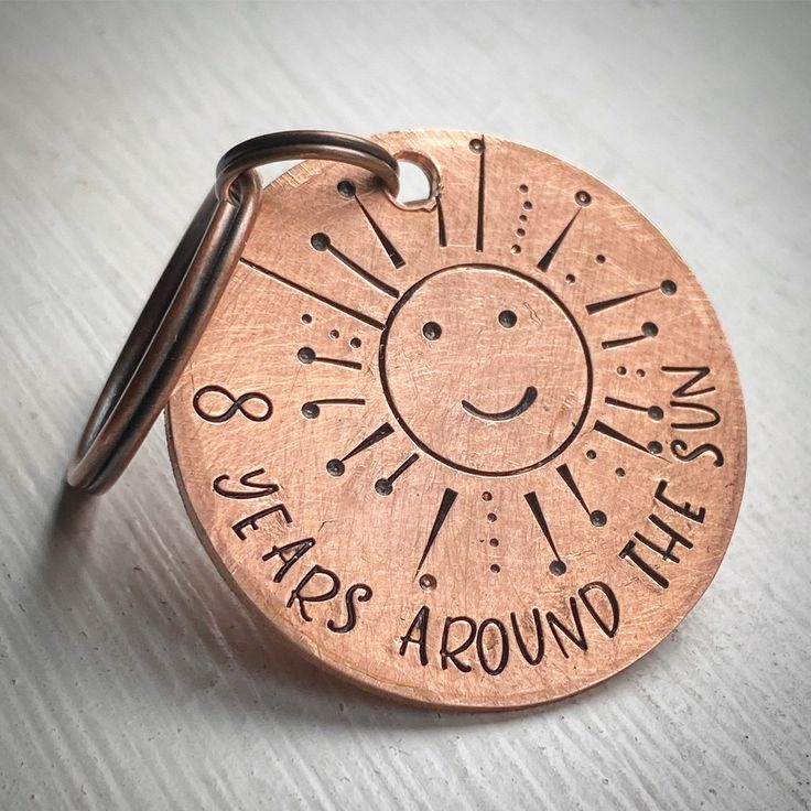 a metal keychain that has a sun on it with the words, yes was around the sun