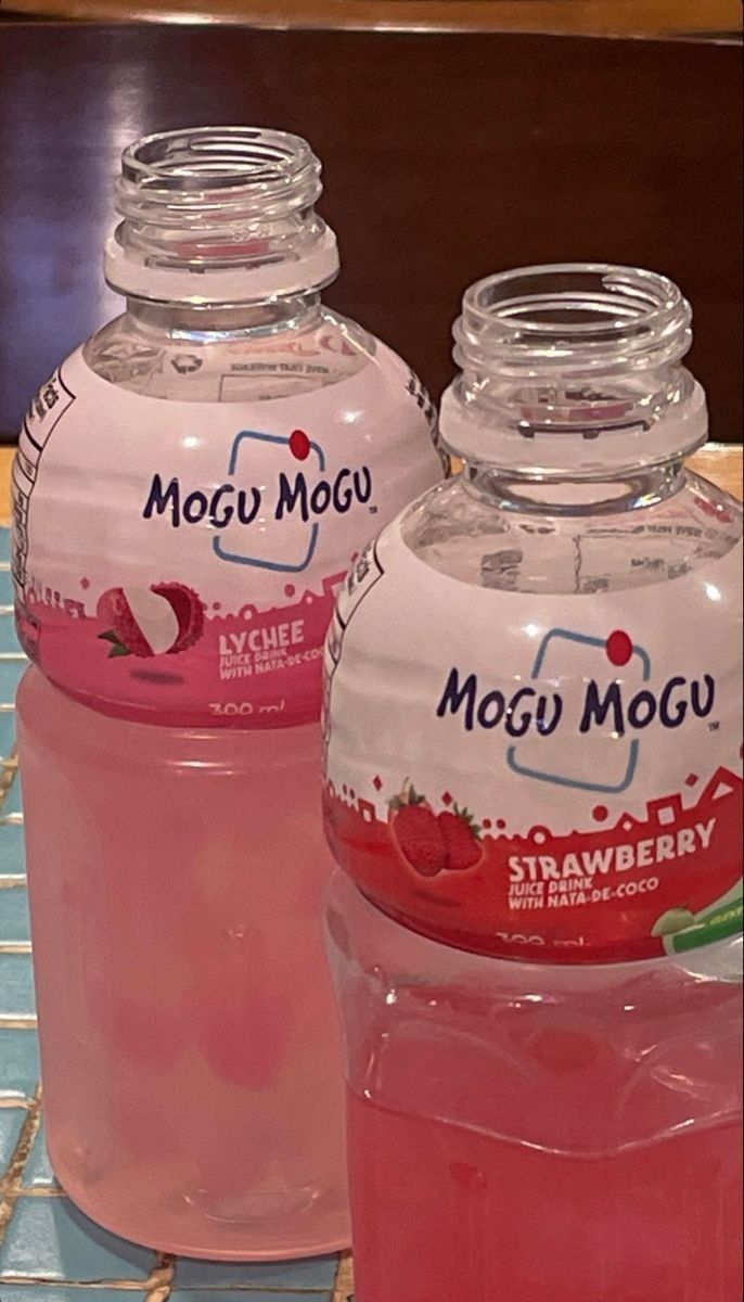 three bottles of mogi moggu sitting on top of a blue tile counter