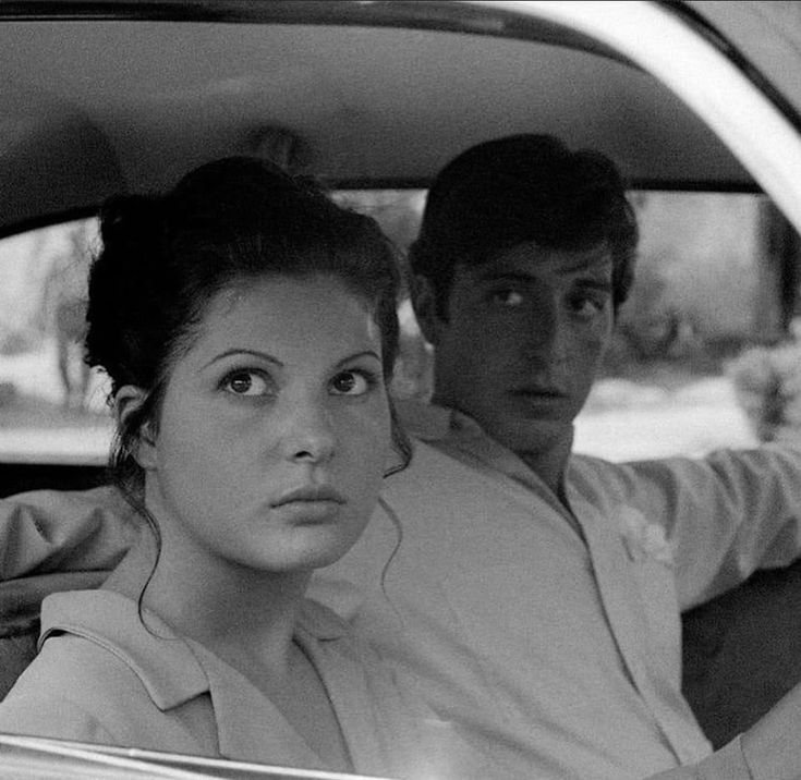 a man and woman sitting in the back seat of a car