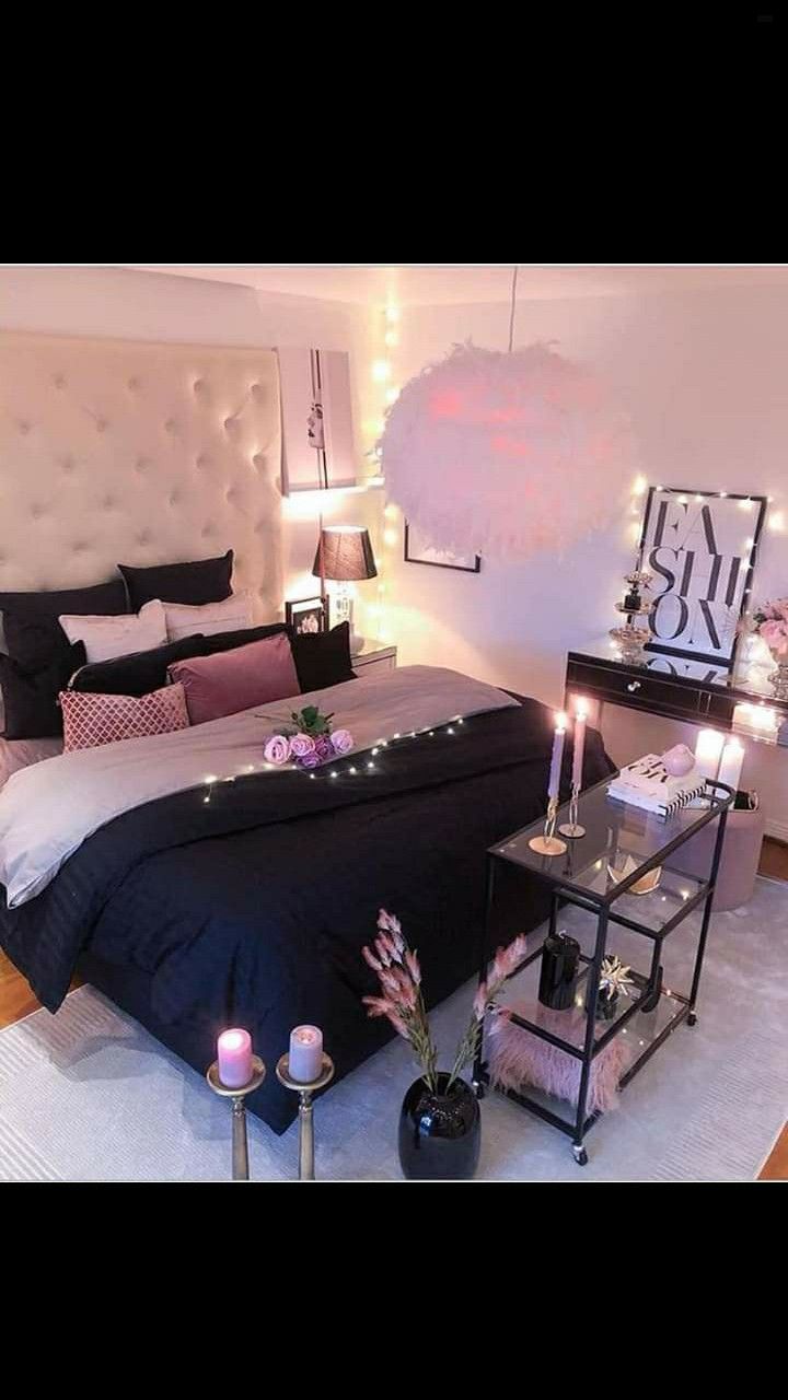 a bedroom decorated in black and white with candles on the bed, nightstands and other decorations