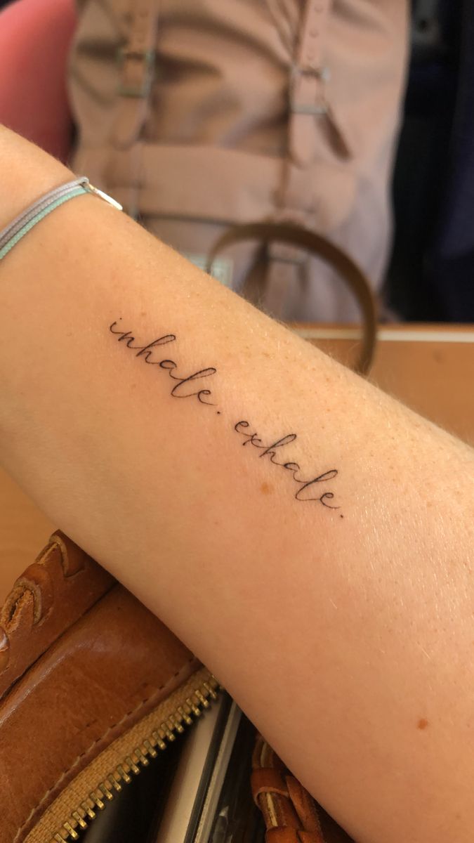 a person with a tattoo on their arm that says, we are all here and there is