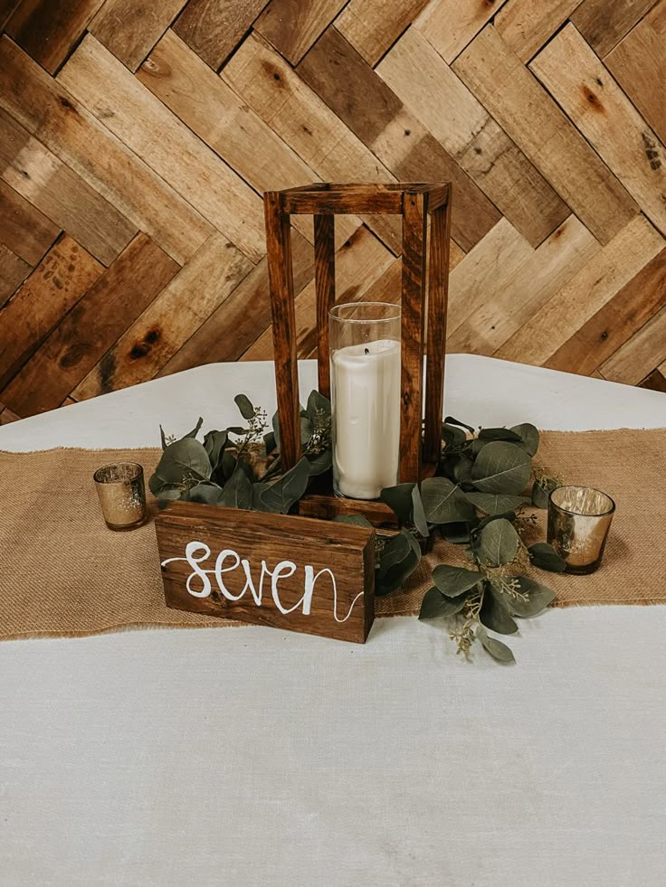 a candle and some candles sitting on a table with a sign that says seven in front of it