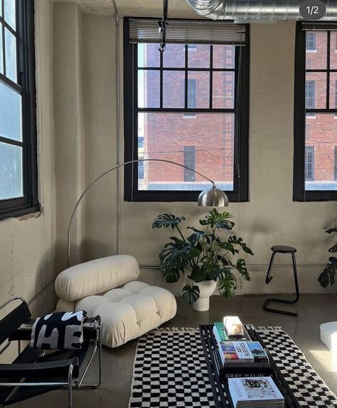 a living room with black and white checkered rugs on the floor next to two windows