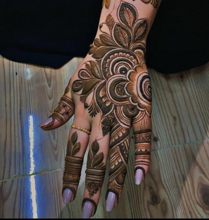 a woman's hand with henna tattoos on it