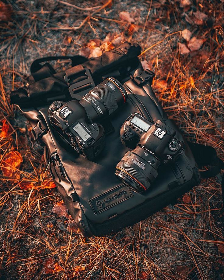 a camera bag sitting on the ground next to other cameras