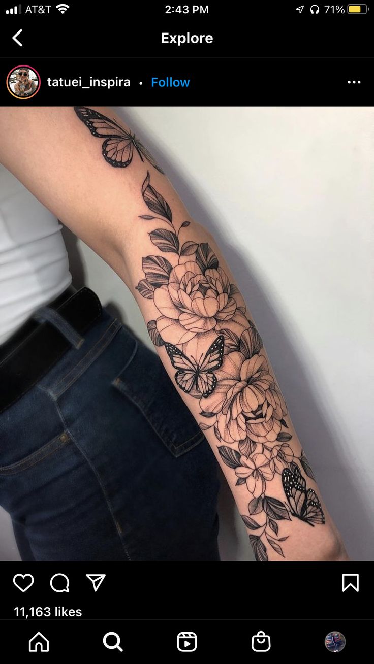 a woman's arm with flowers and butterflies tattooed on the side of her arm