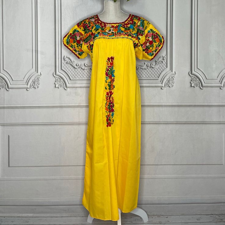 Gorgeous San Antonio dress hand embroidered on both sides with cotton thread on poplin fabric. The fine detail of the dress is a staple of the state of Oaxaca, Mex. Artisans take up to one year to complete one dress. Available in many colors. Match it with one of our Mexican Accessories: Espadrilles, Necklace, Shawl, or Mexican Clutch. Perfect for any Mexican Themed party celebration. Look at our entire San Antonio Collection here. MATERIAL:Dress - 100% Cotton Poplin Embroidery - Cotton SIZE CHA Cotton Dresses With Multicolor Embroidery For Traditional Ceremonies, Traditional Cotton Dresses With Tonal Embroidery, Cotton Dress With Embroidered Border For Traditional Ceremonies, Traditional Embroidered Fiesta Maxi Dress, Traditional Yellow Embroidered Cotton Dress, Traditional Embroidered Maxi Dress For Fiesta, Yellow Embroidered Folk Dress, Yellow Folk Style Embroidered Dress, Traditional Yellow Dress With Embroidered Border