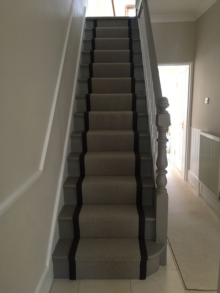 a staircase with carpeted steps leading up to the second floor