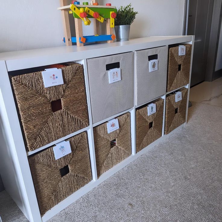 a white shelf with baskets and toys on it