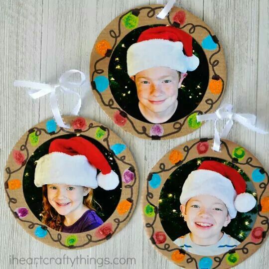 three christmas ornaments with two children's faces in santa hats on the front and back