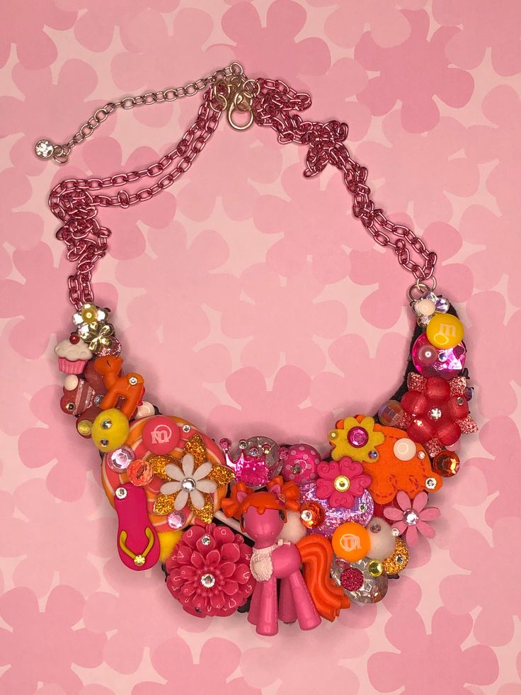 "💗 Unleash your inner enchantress with our one-of-a-kind Lalaloopsy-inspired hot pink and orange pony charm necklace! This whimsical masterpiece is a fusion of magic and charm, designed to captivate hearts and spark joy in every step you take. Crafted with meticulous attention to detail, the adorable hot pink pony charm brings a dash of sweetness, while the vibrant orange accents ignite a sense of playful energy. Embrace the nostalgia of Lalaloopsy with a modern twist as you wear this delightful necklace. Its dainty chain adds a touch of elegance, making it a versatile accessory for any occasion. Whether you're a devoted Lalaloopsy fan or simply seeking a unique statement piece, this captivating necklace promises to be a conversation starter and a cherished addition to your jewelry collec Handmade Orange Jewelry For Birthday, Whimsical Handmade Necklaces For Birthday, Handmade Whimsical Necklace For Birthday, Funky Pink Jewelry For Birthday, Bohemian Pink Jewelry For Birthday, Handmade Pink Fun Jewelry, Handmade Fun Pink Jewelry, Whimsical Handmade Necklaces For Birthdays, Handmade Multicolor Charm Necklaces For Parties