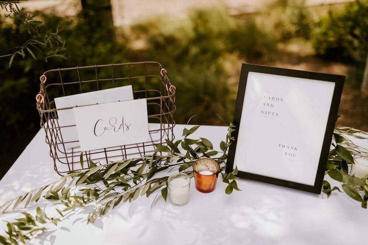 a white table topped with a framed sign next to a candle holder filled with candles